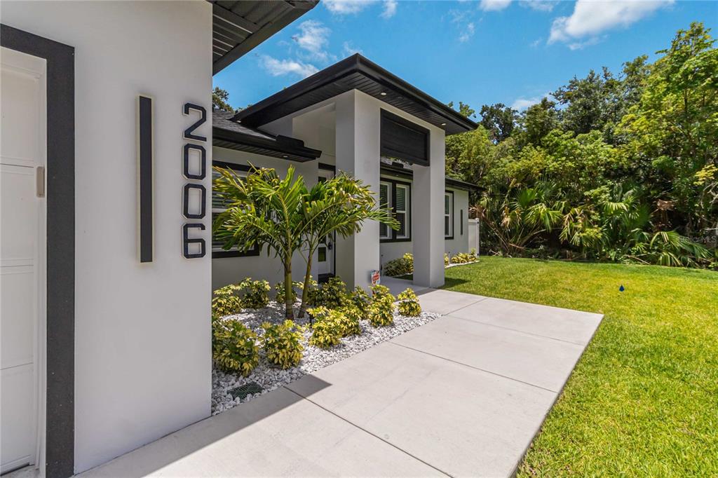 A modern house exterior features white walls, black trim, and a concrete walkway — 2006 WILLIAMS AVENUE, SANFORD, FL