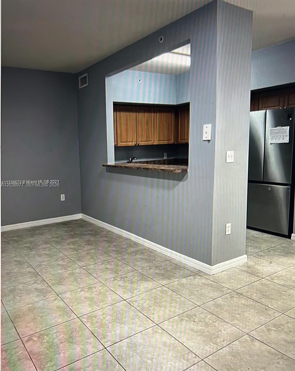 A view of a dining area with tile floors, gray walls, and a kitchen pass-through — 115 SW 42nd Ave # 206, Miami FL 33134, MIAMI, FL