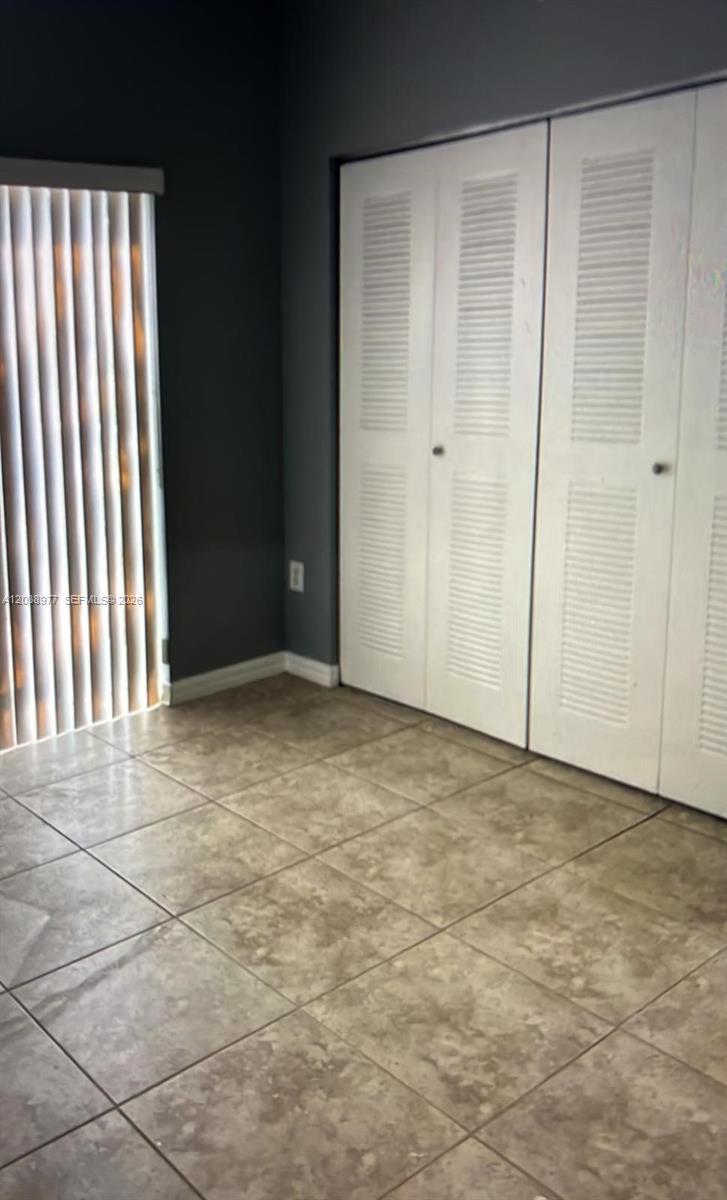 A room with tiled flooring, dark gray walls, and white louvered closet doors — 115 SW 42nd Ave # 206, Miami FL 33134, MIAMI, FL