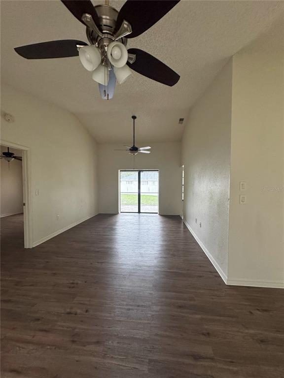 An interior view of a room with wood-look flooring, vaulted ceilings, and two ceiling fans — 2378 COMERWOOD DRIVE, SPRING HILL, FL