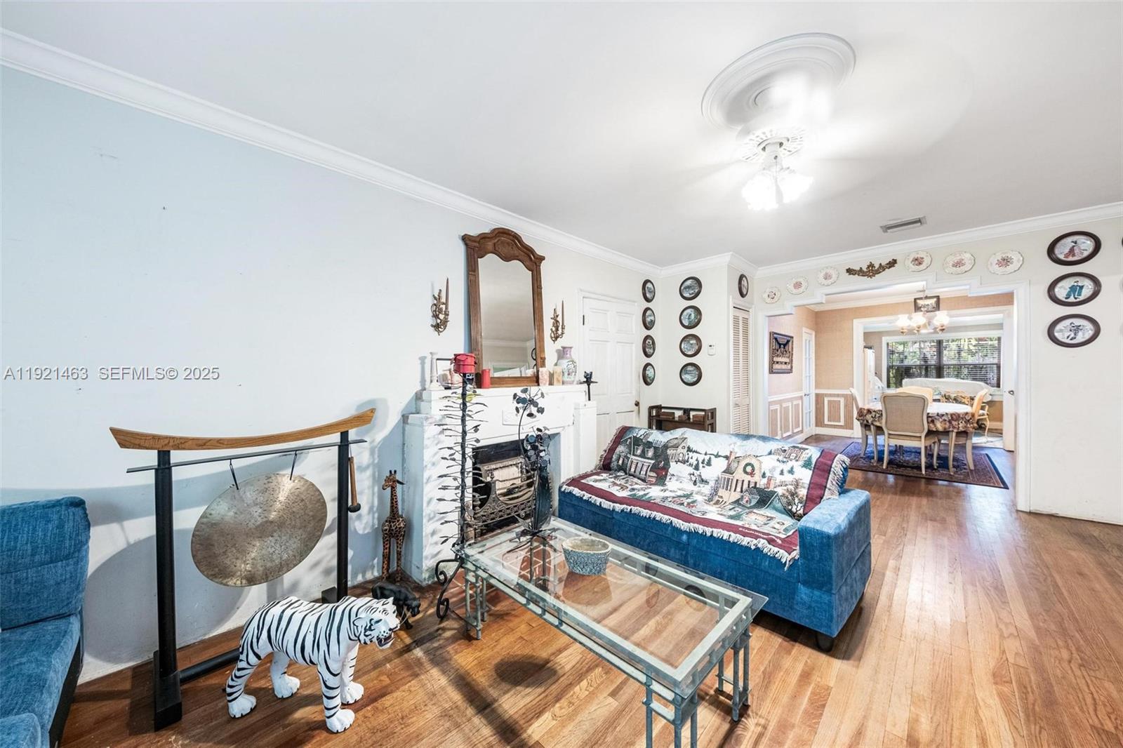 A living room features a fireplace, a blue sofa, a glass coffee table, and hardwood floors — 37 NE 44th St, Miami FL 33137, MIAMI, FL