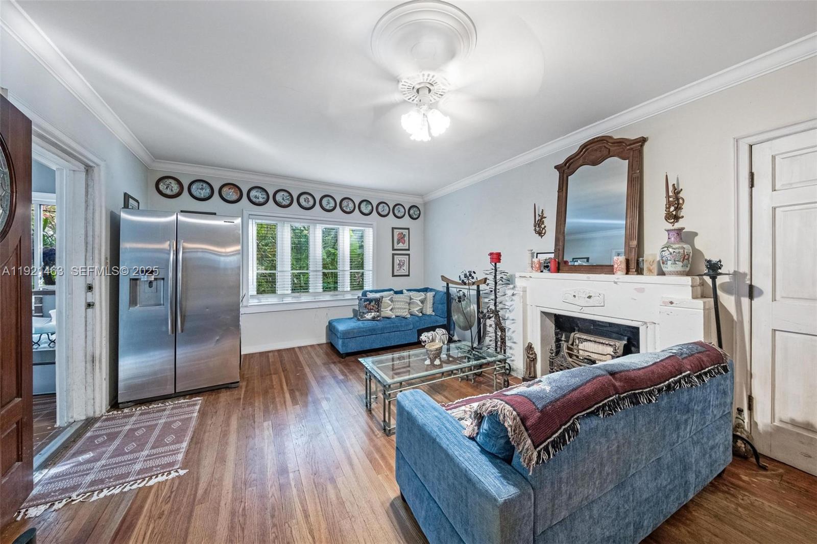 A living room features a fireplace, a stainless steel refrigerator, and blue upholstered furniture — 37 NE 44th St, Miami FL 33137, MIAMI, FL