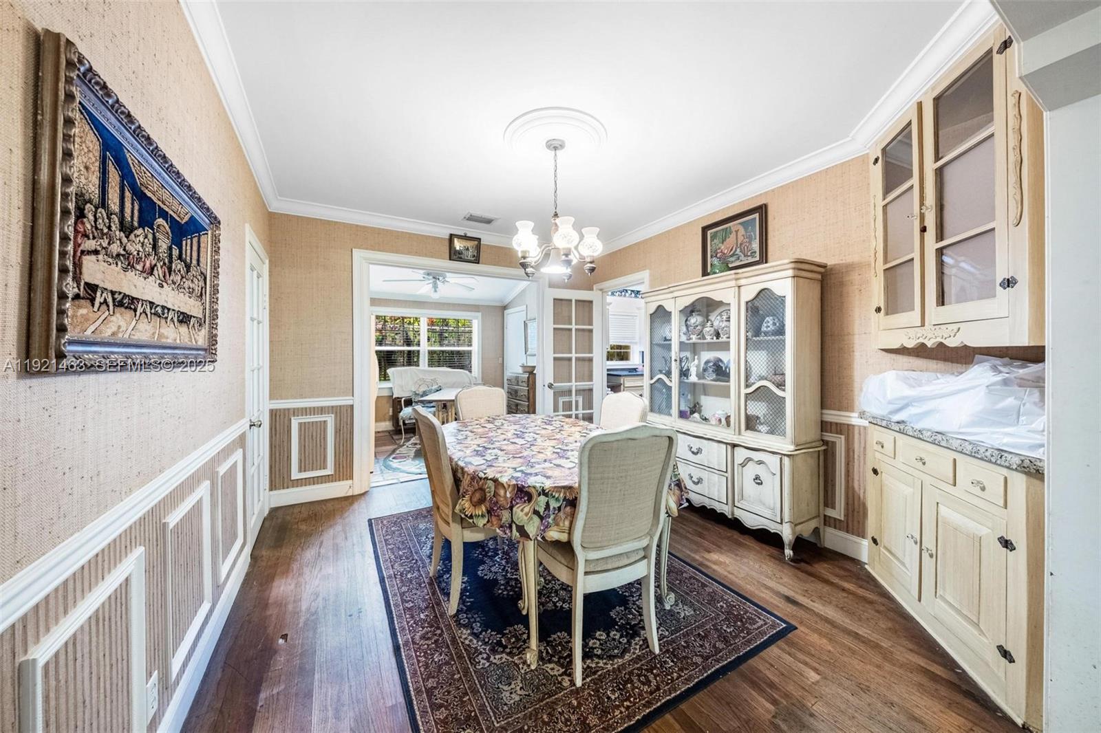 A dining room features a floral tablecloth, a hutch, and wood flooring — 37 NE 44th St, Miami FL 33137, MIAMI, FL