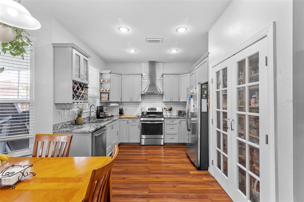 A kitchen with gray cabinets, stainless steel appliances, and wood flooring — 10237 GOLDENBROOK WAY, TAMPA, FL