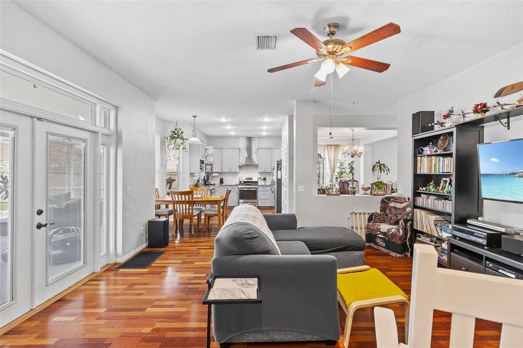 A living room with hardwood floors opens to a kitchen and dining area — 10237 GOLDENBROOK WAY, TAMPA, FL