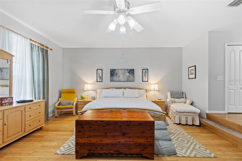 A bedroom features a bed, a wooden chest, a yellow chair, and a chaise lounge — 10237 GOLDENBROOK WAY, TAMPA, FL