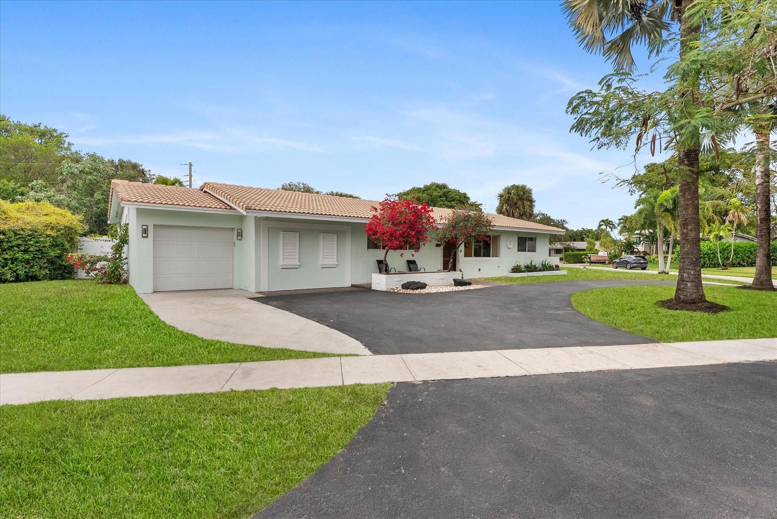A single-story house with a light green exterior, a tile roof, and a paved driveway — 1257 NW 5th Street, Boca Raton FL 33486, BOCA RATON, FL