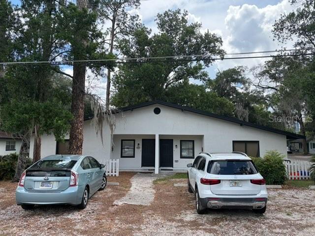A single-story duplex with a white exterior and two cars parked in front — 615 NW 15TH STREET, GAINESVILLE, FL