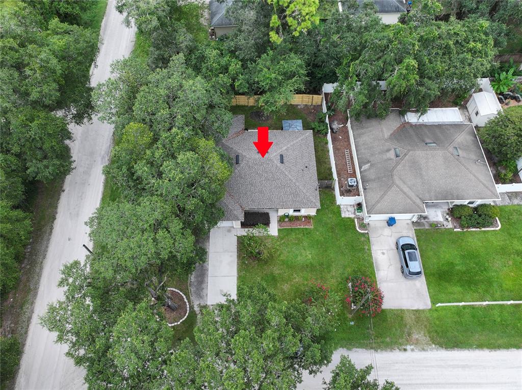 An aerial view shows a single-story house with a gray shingled roof and a driveway — 1495 3RD STREET, ORANGE CITY, FL