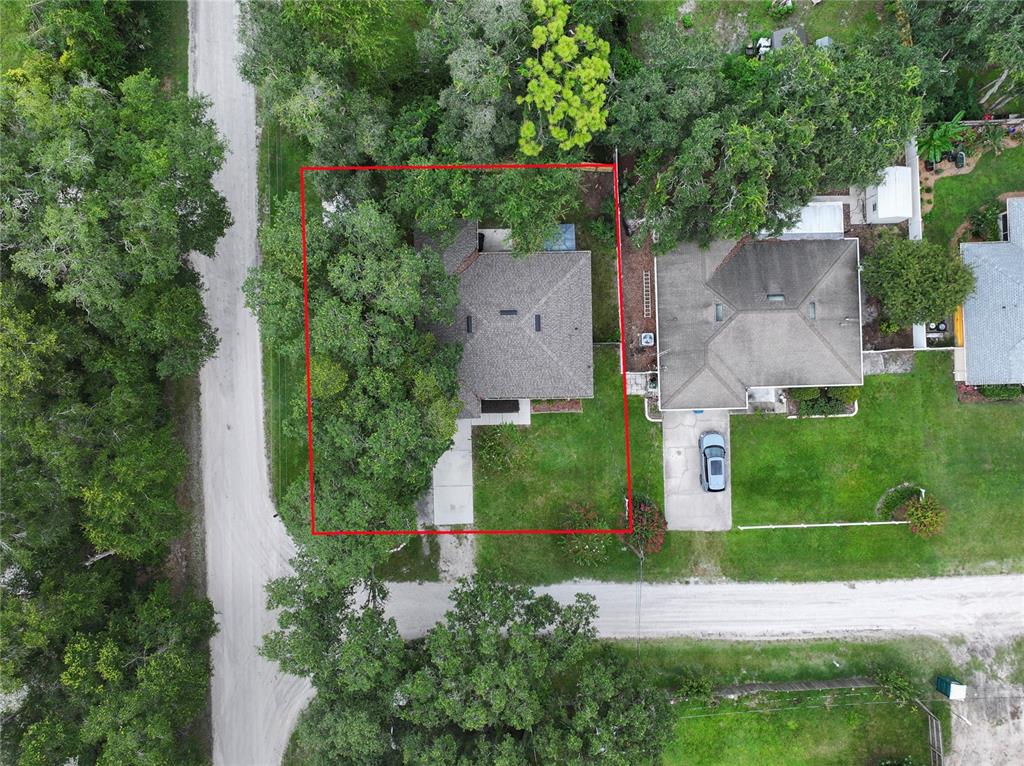 An aerial view shows a house with a red boundary line on a wooded lot — 1495 3RD STREET, ORANGE CITY, FL