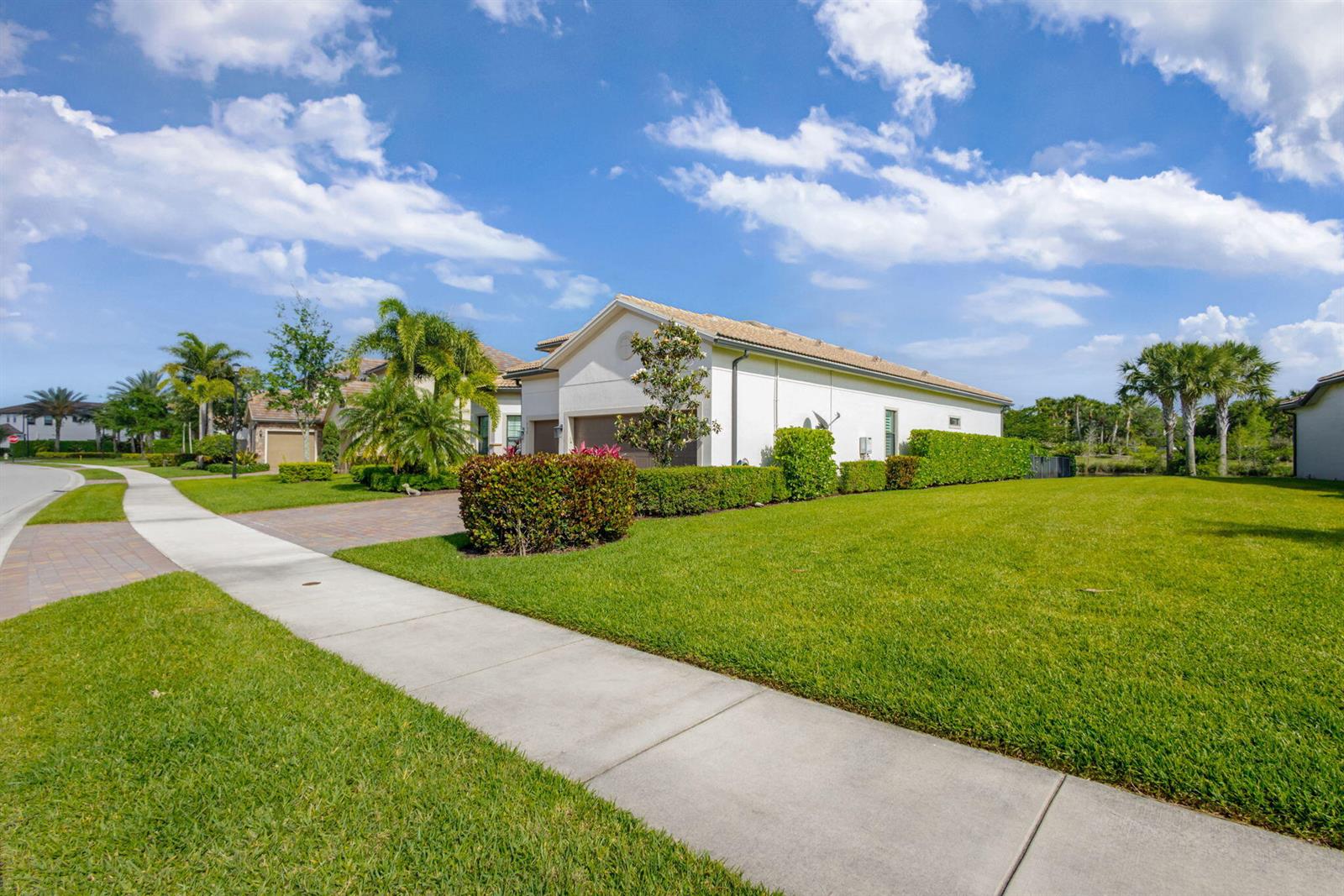 A single-story house with a white exterior, a paved driveway, and a manicured lawn — 532 Sonoma Isles Circle, Jupiter FL 33478, JUPITER, FL