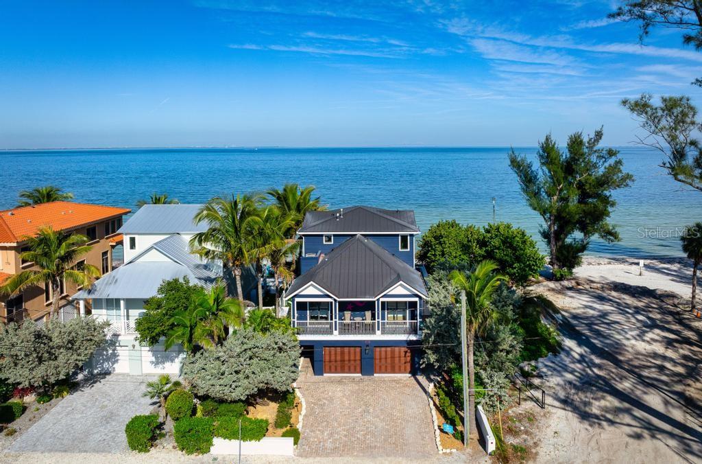 An aerial view of a beachfront house circled in white along a coastal residential area — 915 N SHORE DRIVE, ANNA MARIA, FL