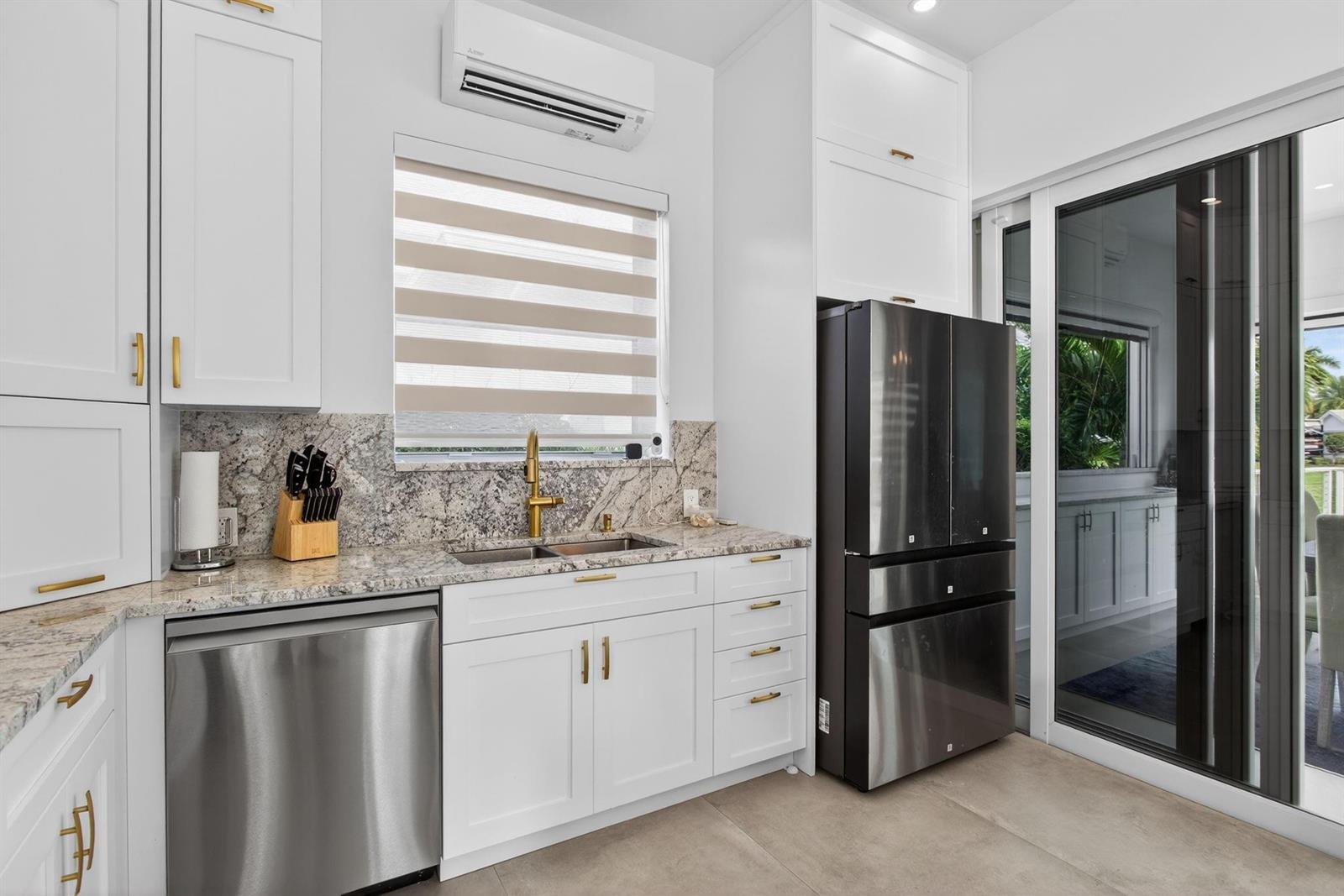 A kitchen features white cabinets, granite countertops, stainless steel appliances, and a window with blinds — 633 N Cortez Drive # 633, Margate FL 33068, MARGATE, FL