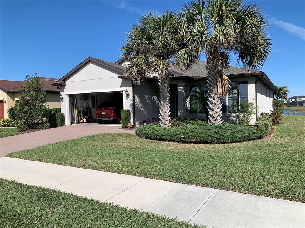 A single-story house with a two-car garage, palm trees, and a landscaped front yard — 2536 MARTON OAK BOULEVARD, NORTH PORT, FL