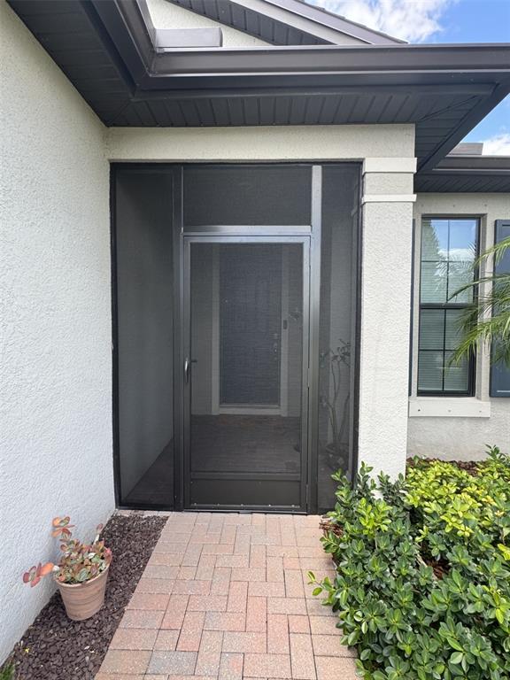 A front entryway features a dark metal screen door and a brick paver walkway — 2536 MARTON OAK BOULEVARD, NORTH PORT, FL