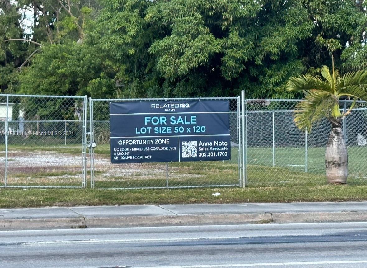 A chain-link fence surrounds a vacant lot with a real estate sign in the foreground — 2065 NW 54th street, Miami FL 33142, MIAMI, FL