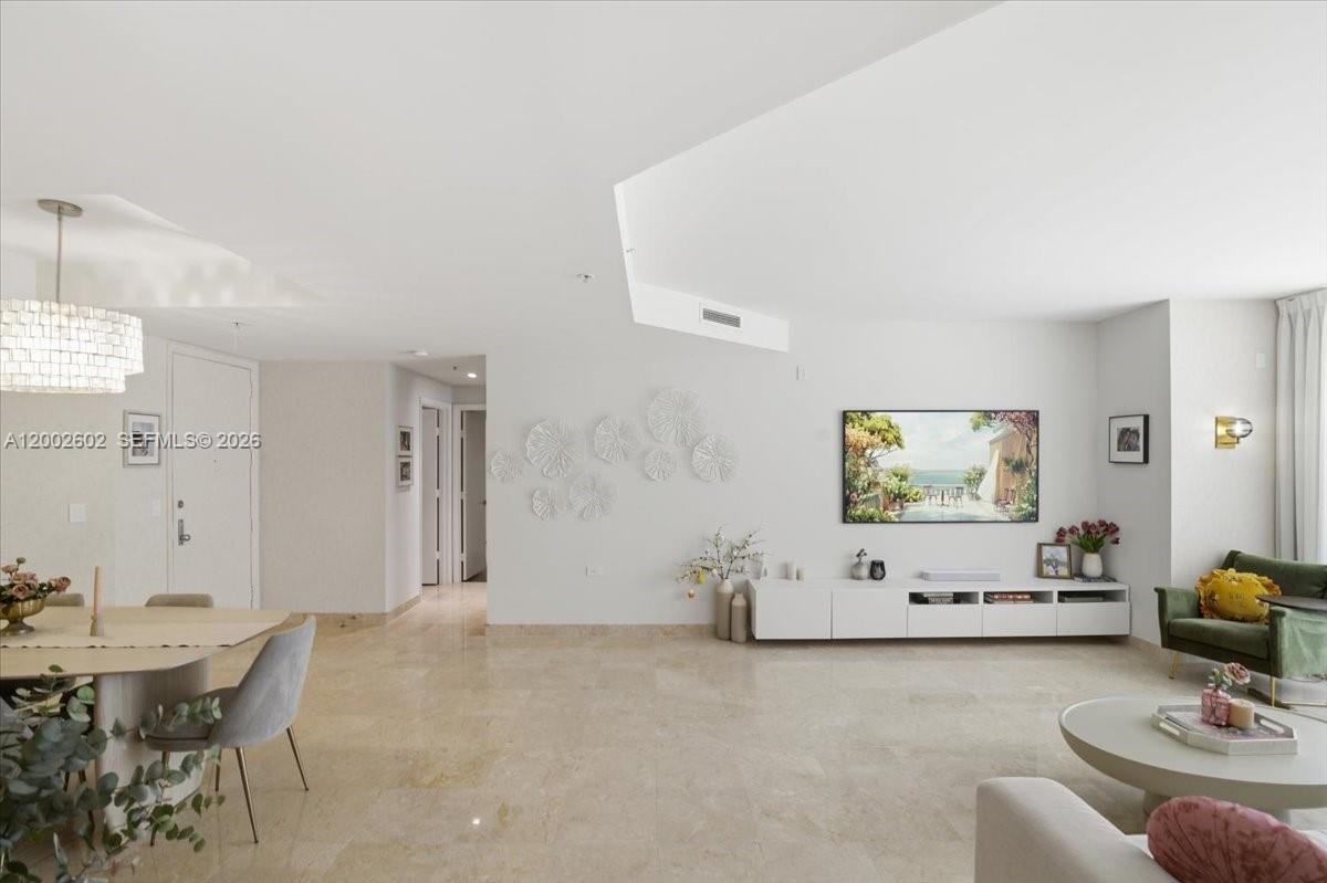 A bright, open-concept living and dining area features white walls, marble floors, and modern decor — 801 Brickell Key Blvd # 409, Miami FL 33131, MIAMI, FL