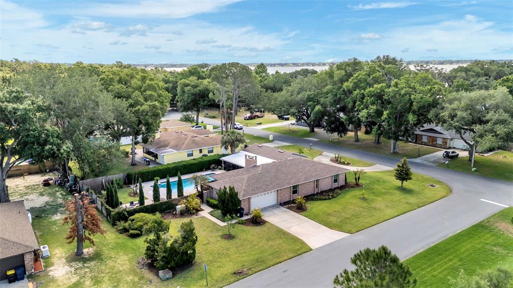 An aerial view shows a single-story house with a swimming pool and a large yard — 906 CRESTVIEW DRIVE, AUBURNDALE, FL
