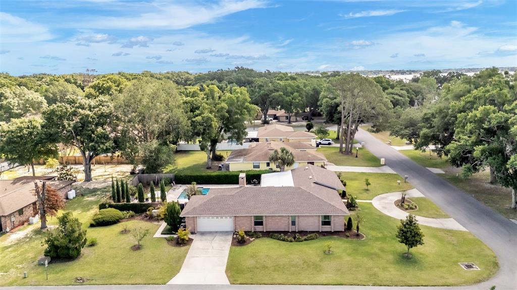 An aerial view shows a single-story brick house with a swimming pool and large yard — 906 CRESTVIEW DRIVE, AUBURNDALE, FL
