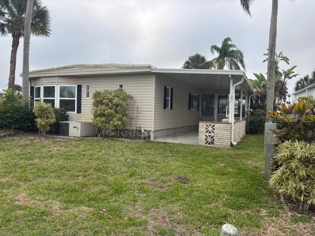 A single-story manufactured home with light siding, a carport, and surrounding landscaping — 2100 KINGS HIGHWAY UNIT 781, PORT CHARLOTTE, FL