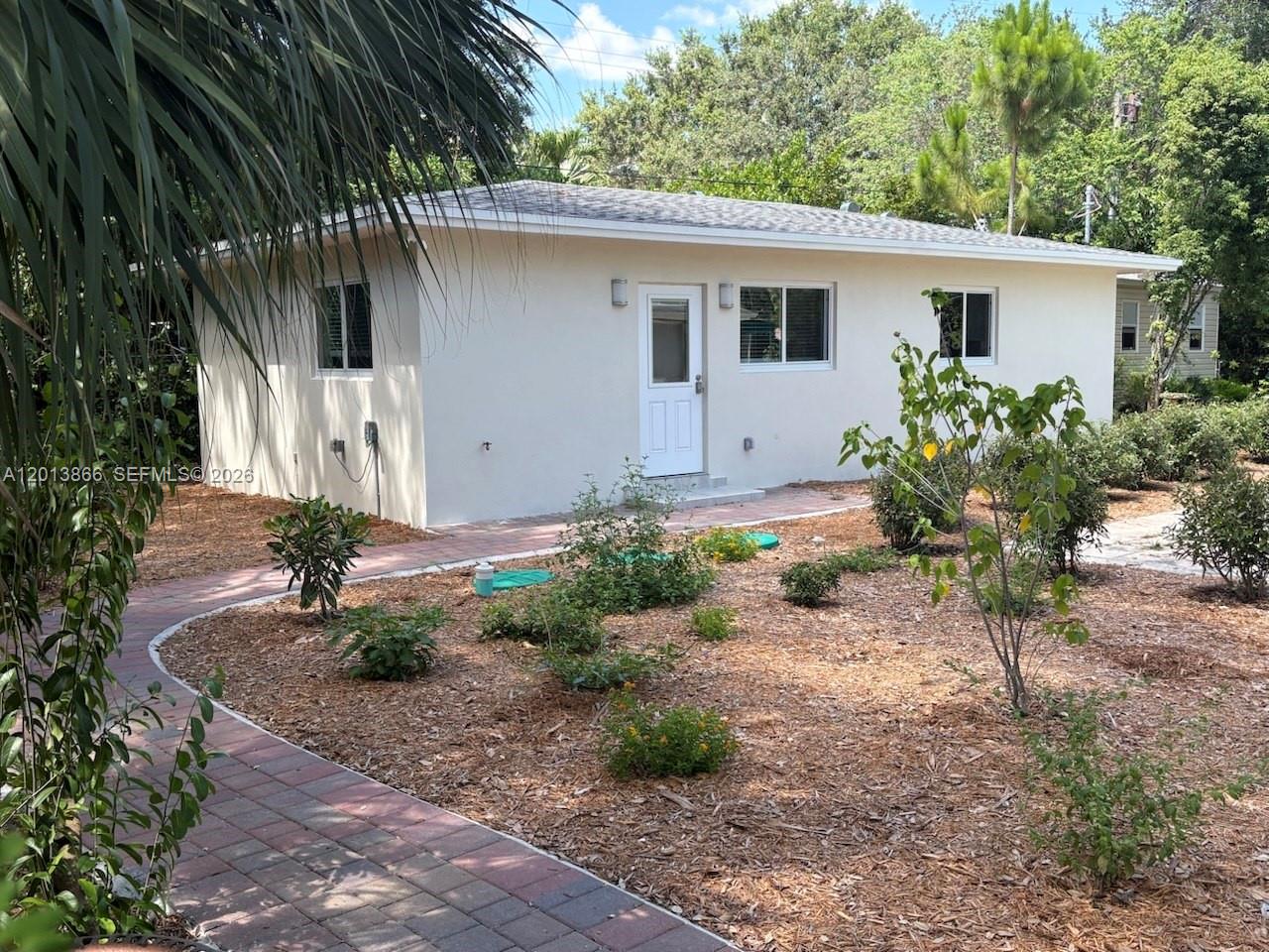 A single-story house with a white exterior, a paved walkway, and a landscaped yard — 8442 SW 107th St, Miami FL 33156, MIAMI, FL