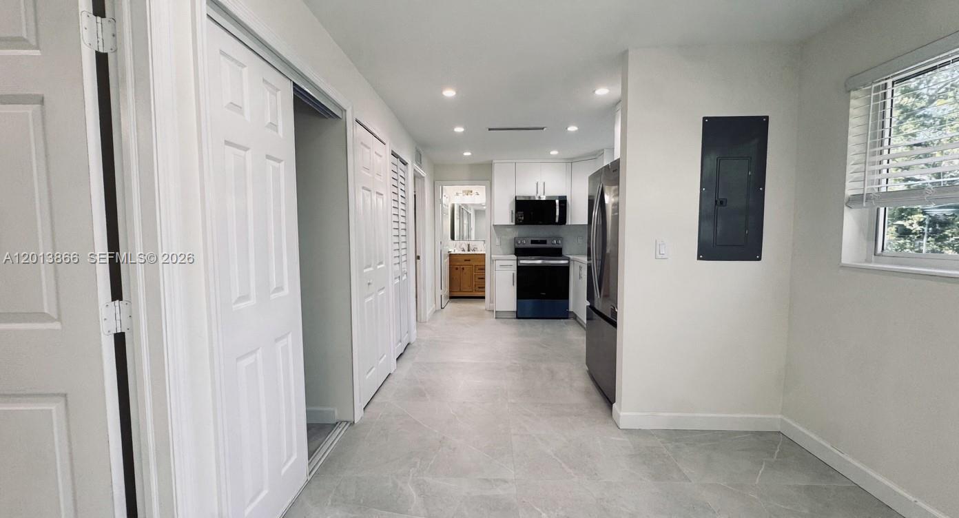 A kitchen with white cabinets, stainless steel appliances, and light gray tile flooring — 8442 SW 107th St, Miami FL 33156, MIAMI, FL