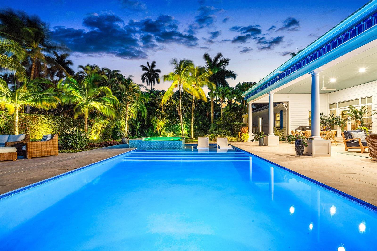 A swimming pool and hot tub sit on a patio beside a house with palm trees — 1101 Thomas Street, Delray Beach FL 33483, DELRAY BEACH, FL