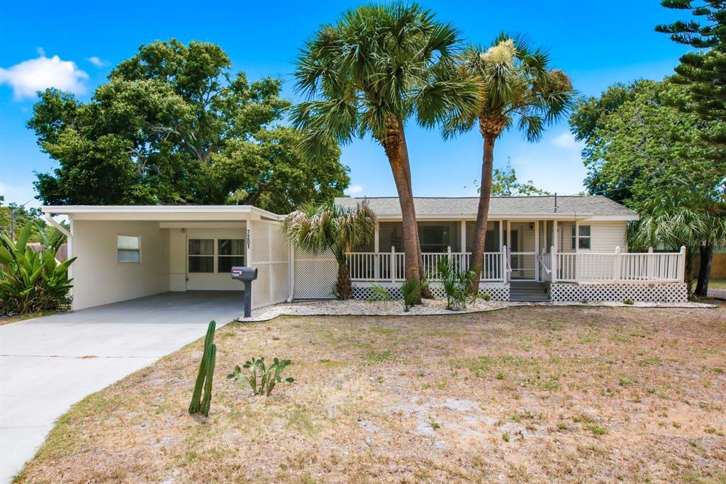 A single-story house with a carport, a front porch, and palm trees in the yard — 7201 5TH AVENUE N, ST PETERSBURG, FL