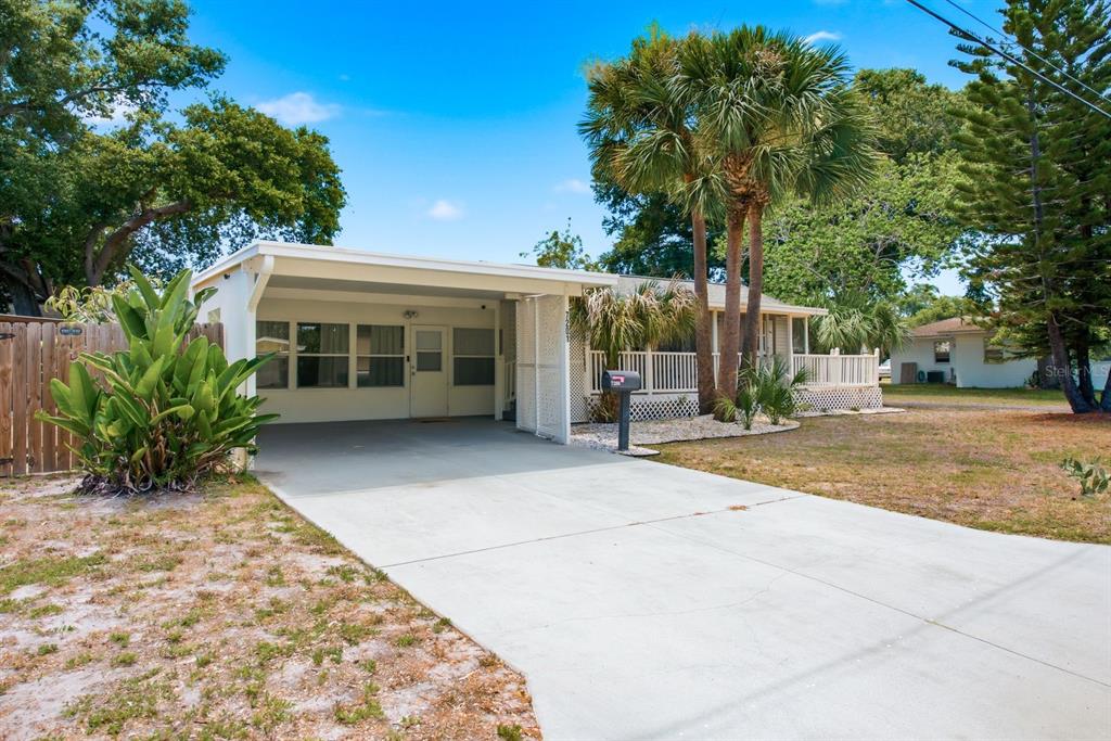 A single-story house with a carport, a front porch, and palm trees in the yard — 7201 5TH AVENUE N, ST PETERSBURG, FL