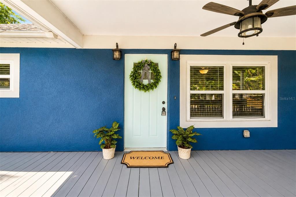 A blue exterior wall features a light green front door with a wreath and welcome mat — 140 PAGE STREET, ORLANDO, FL