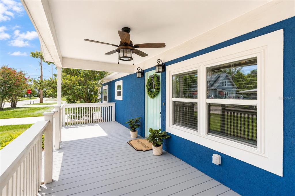 A blue house exterior features a covered front porch with a ceiling fan and railing — 140 PAGE STREET, ORLANDO, FL