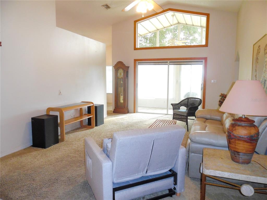 A living room features a sofa, two armchairs, a coffee table, and a television — 24947 CRANES ROOST CIRCLE, LEESBURG, FL