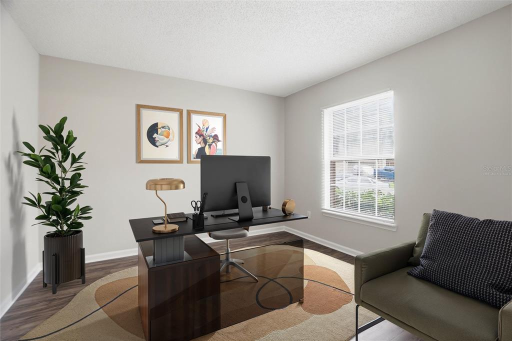 A home office features a modern desk, a chair, an area rug, and a window — 5736 GUANA PARK COURT, JACKSONVILLE, FL