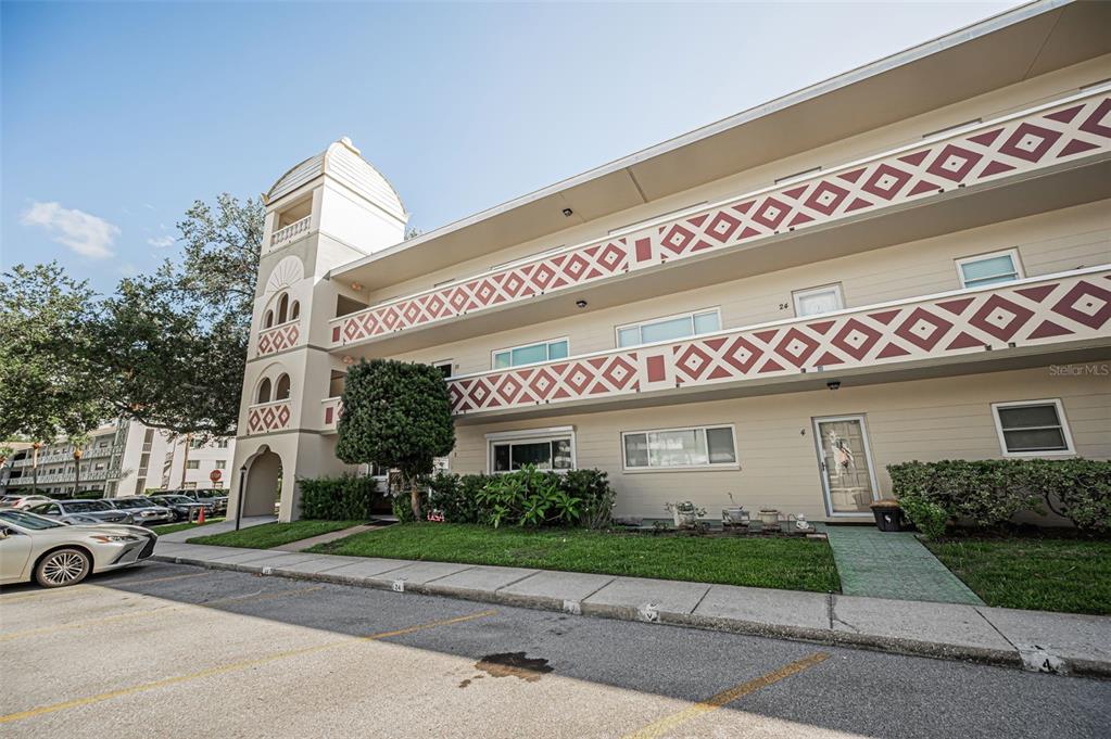 A multi-story apartment building features a decorative geometric railing and a prominent corner tower — 2384 TAHITIAN LANE UNIT 22, CLEARWATER, FL