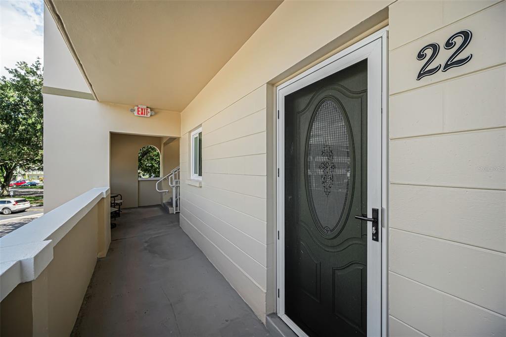 An exterior walkway leads to a front door marked with the number 22 — 2384 TAHITIAN LANE UNIT 22, CLEARWATER, FL