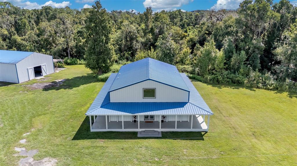 An aerial view shows a metal-roofed house with a wrap-around porch and a separate garage — 4141 KATHLEEN ROAD, LAKELAND, FL