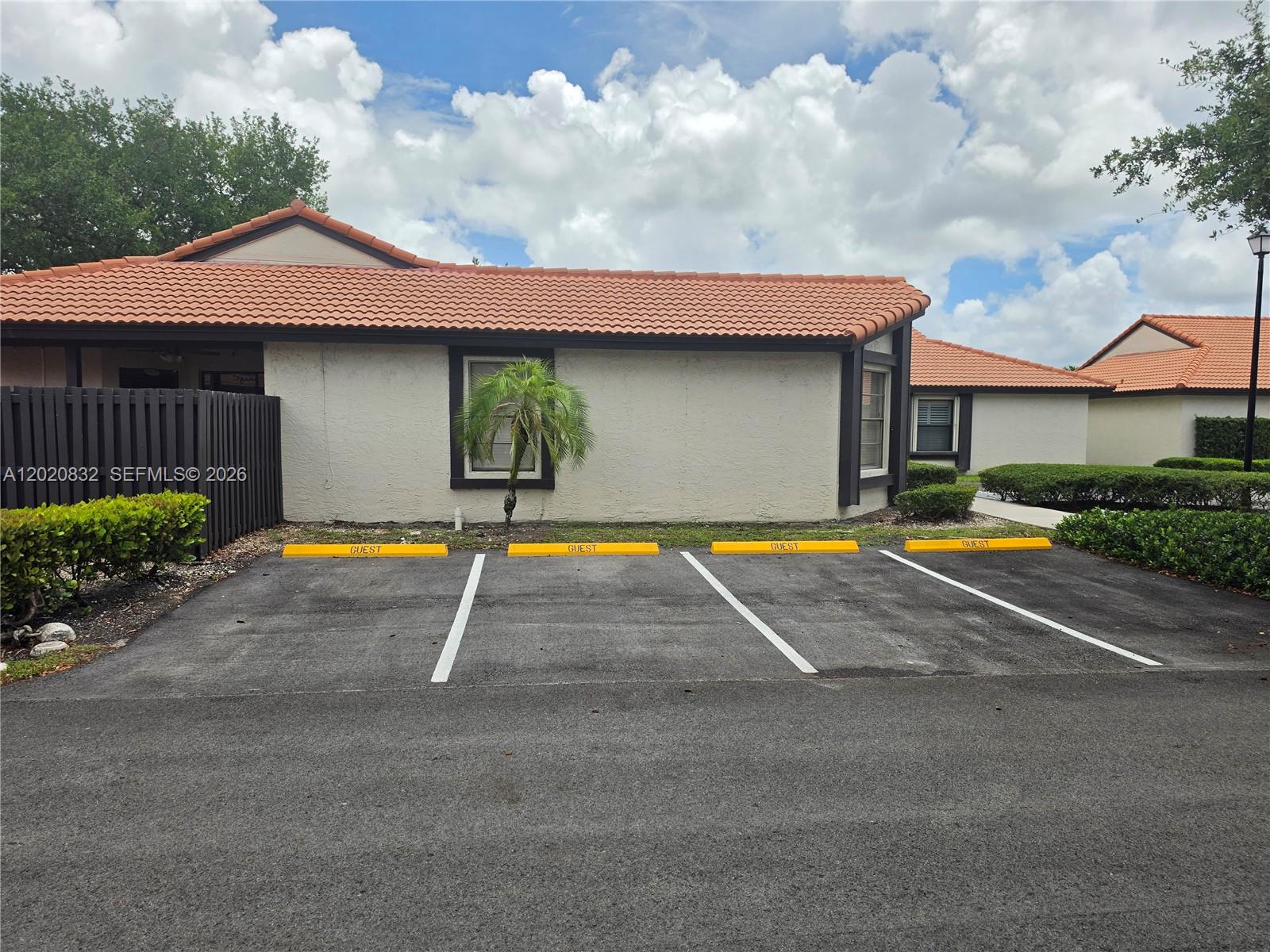 Four guest parking spaces are located in front of a single-story building with a tiled roof — 15240 SW 45th Ter # 54F, Miami FL 33185, MIAMI, FL