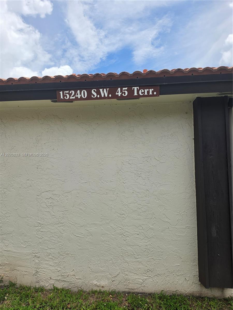 The exterior wall of a building features a house number plaque under a tiled roof — 15240 SW 45th Ter # 54F, Miami FL 33185, MIAMI, FL