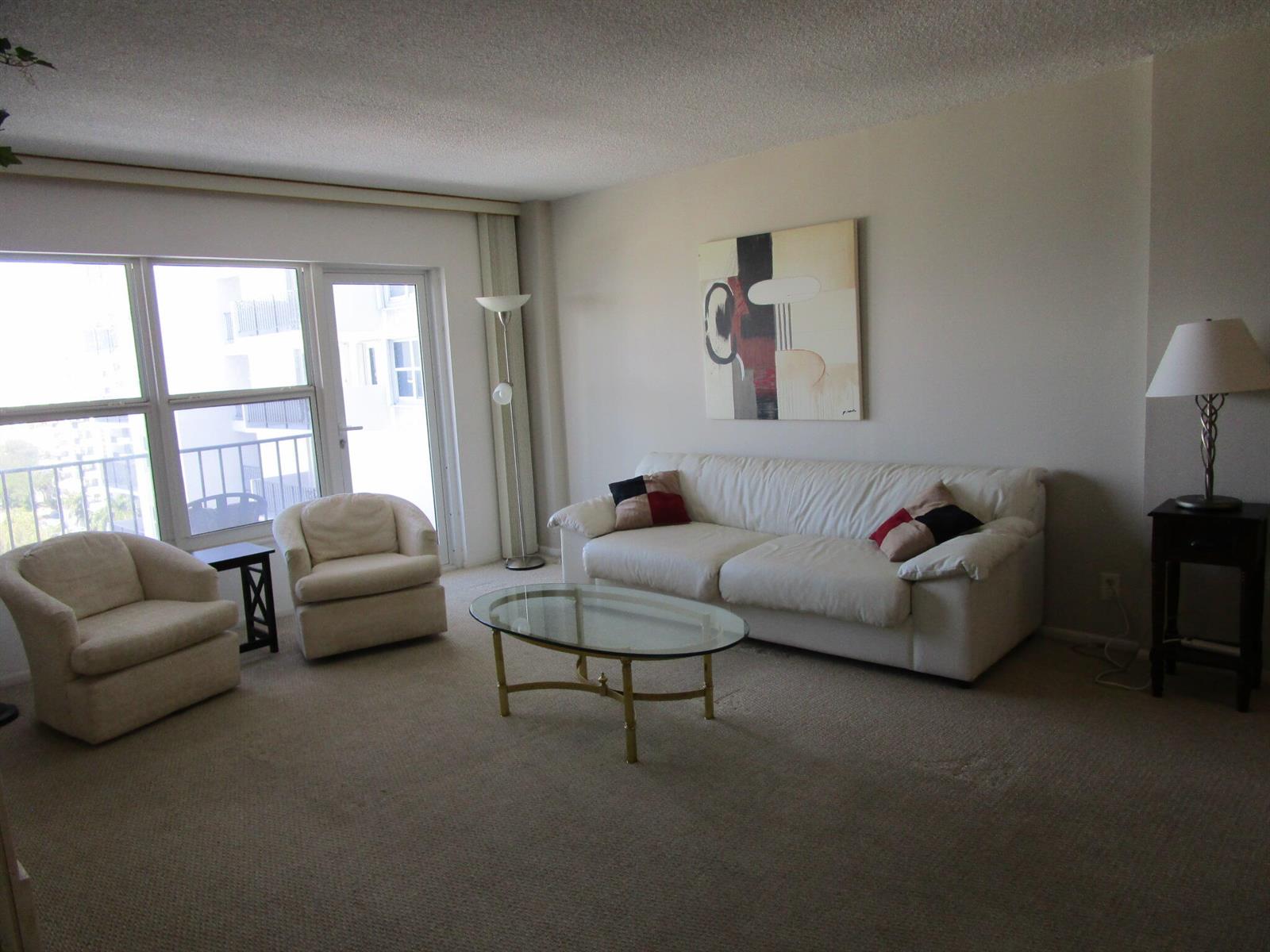 A living room features a white sofa, two armchairs, a glass coffee table, and carpeted floors — 405 N Ocean Boulevard # 1225, Pompano Beach FL 33062, POMPANO BEACH, FL