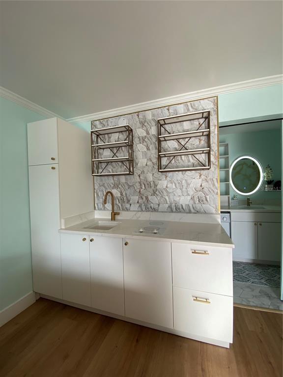 A kitchenette features white cabinets, a marble-patterned backsplash, gold hardware, and open metal shelving — 7150 N TAMIAMI TRAIL UNIT S521, SARASOTA, FL