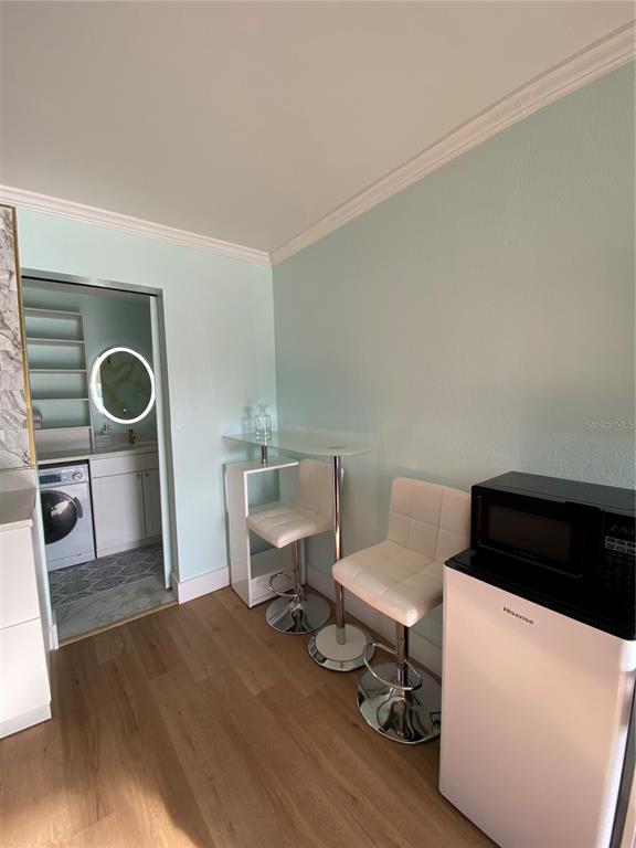 A small room features a glass breakfast bar with two stools and a mini-fridge — 7150 N TAMIAMI TRAIL UNIT S521, SARASOTA, FL