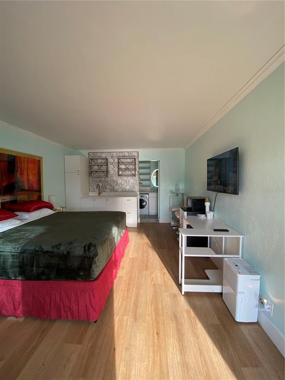A bedroom features a bed with a red skirt, a small kitchenette, and a desk — 7150 N TAMIAMI TRAIL UNIT S521, SARASOTA, FL