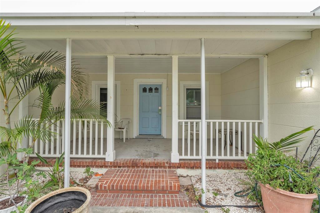 A covered front porch with white railings and a light blue door leads to a home — 752 LANTANA AVENUE, CLEARWATER BEACH, FL