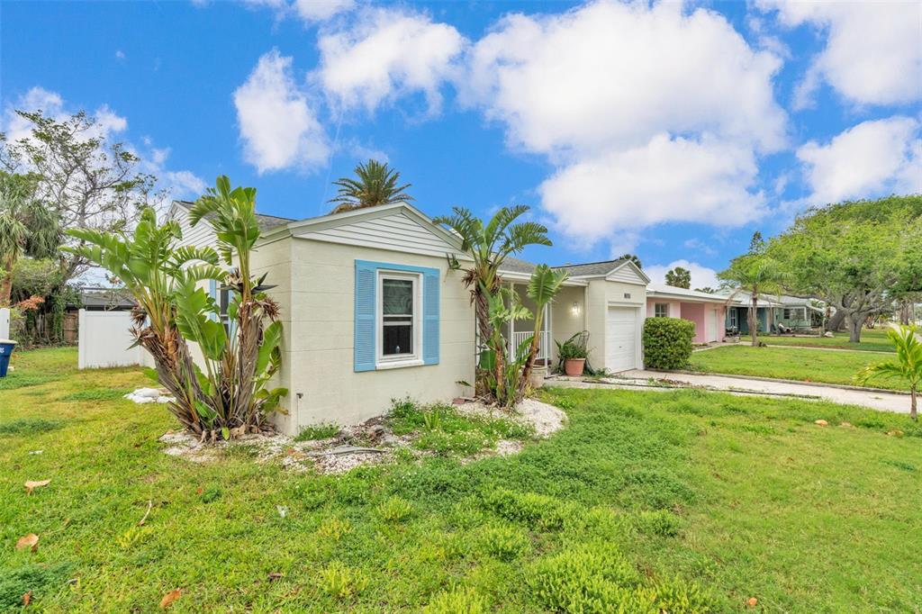 A single-story house with light-colored siding, blue shutters, and palm trees in the front yard — 752 LANTANA AVENUE, CLEARWATER BEACH, FL