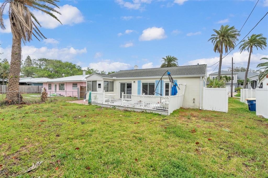 The exterior of a one-story house features a white deck, a fenced yard, and palm trees — 752 LANTANA AVENUE, CLEARWATER BEACH, FL