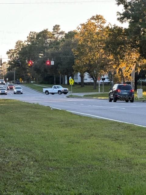 A white pickup truck and a dark SUV drive through an intersection near trees — 1407 COURTLAND BOULEVARD, DELTONA, FL