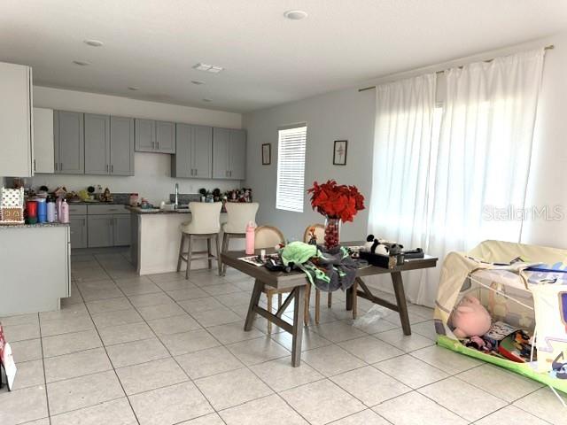 A kitchen with gray cabinets and an island opens to a dining area — 270 TARPON BAY BOULEVARD, HAINES CITY, FL