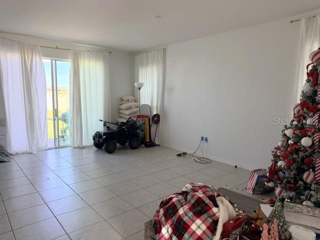 A living room with tile flooring, a sliding glass door, and a decorated Christmas tree — 270 TARPON BAY BOULEVARD, HAINES CITY, FL