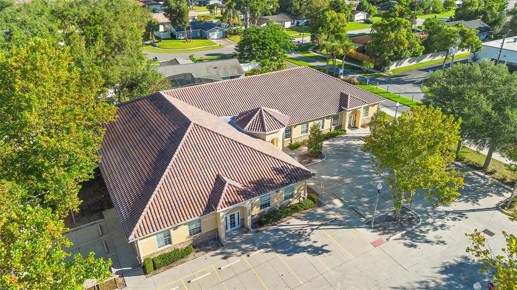 An aerial view shows a commercial building with a tiled roof and an adjacent parking lot — 330 HARBOUR ISLE WAY UNIT 1040, LONGWOOD, FL
