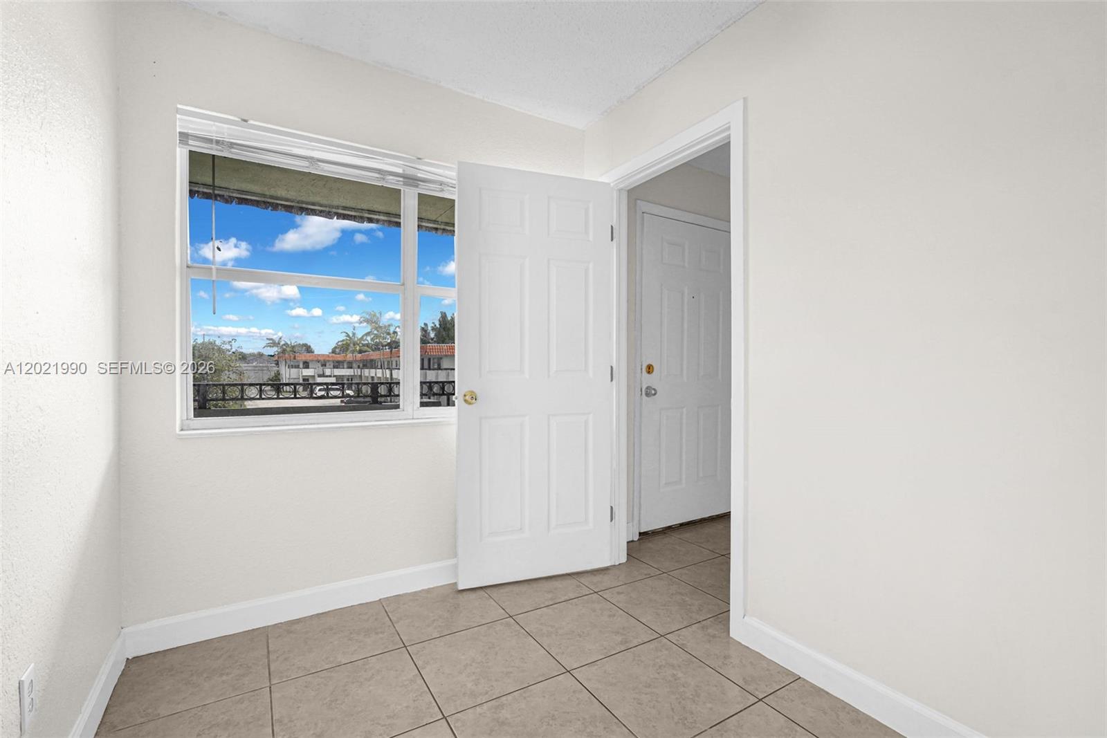 A room with light-colored walls, tiled flooring, a window, and an open door — 400 NW 65th Ave # 222, Margate FL 33063, MARGATE, FL